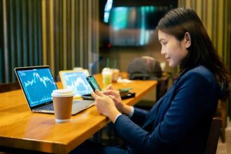 Happy young female stock-picker in a cafe