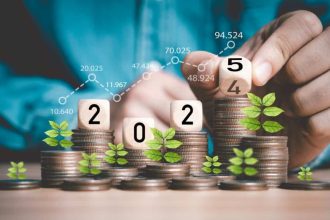 Businessman hand flipping wooden block cube from 2024 to 2025 on coins
