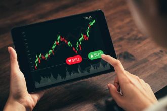 Investor looking at stock graph on a tablet with their finger hovering over the Buy button