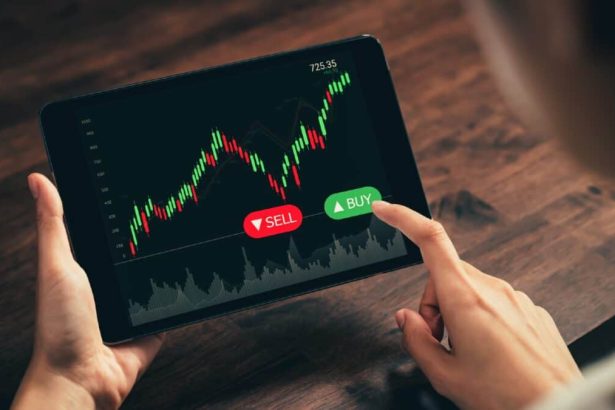 Investor looking at stock graph on a tablet with their finger hovering over the Buy button