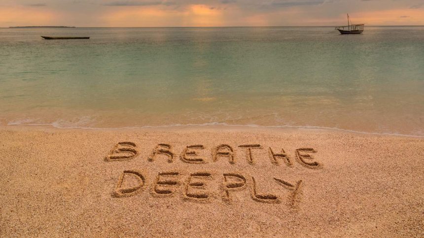 A beach at sunset where there is an inscription on the sand