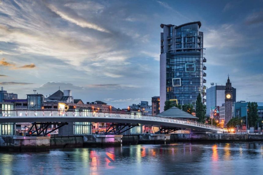 Belfast City Sunset with colorful twilight over Lagan Weir Pedestrian and Cycle Bridge spanning over the Lagan River in downtown Belfast