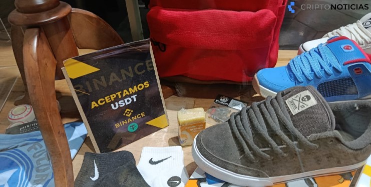 Fotografía de una tienda que vende zapatos, calcetines y tiene un letrero que dice "aceptamos USDT".