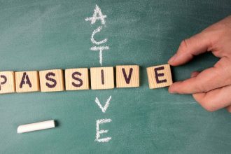 Passive and Active: text from letters of the wooden alphabet on a green chalk board