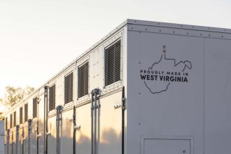 A grid-scale battery stands against a clear sky.