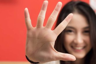Young female hand showing five fingers.