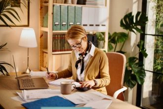 Middle aged businesswoman using laptop while working from home